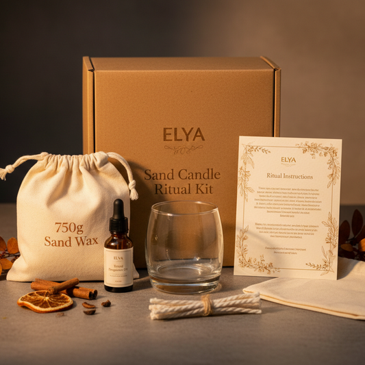 A luxury styled product photograph of a large Sand Candle Ritual Kit (750g) by ELYA arranged neatly with premium packaging. Larger kraft box, sand wax pouch labeled 750g, glass candle pot, fragrance dropper bottle, ritual instruction card, cotton wicks, folded canvas pouch. Warm amber lighting, autumn botanical accents, matte stone background, soft shadows, calm ritual atmosphere, premium handcrafted brand style, depth of field blur background, professional ecommerce hero image.